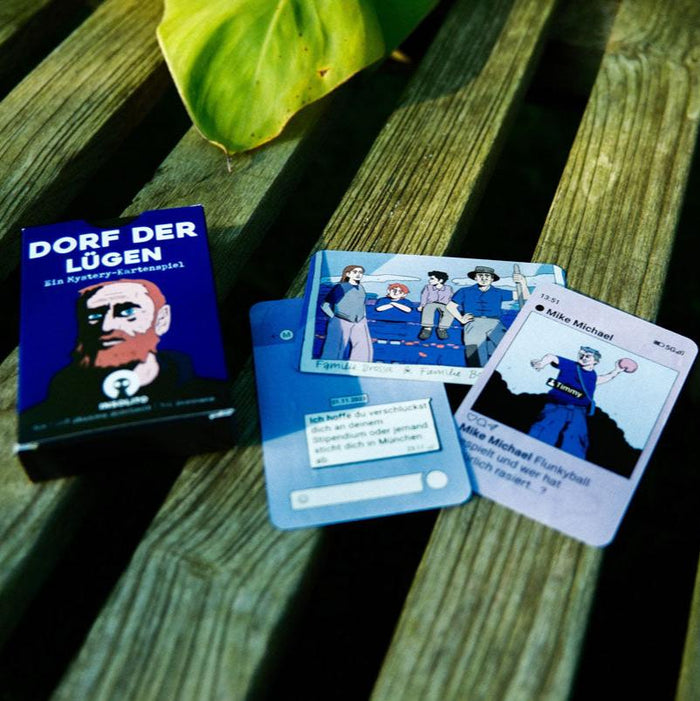 Karten von „Das Dorf der Lügen“ auf einer Holzbank